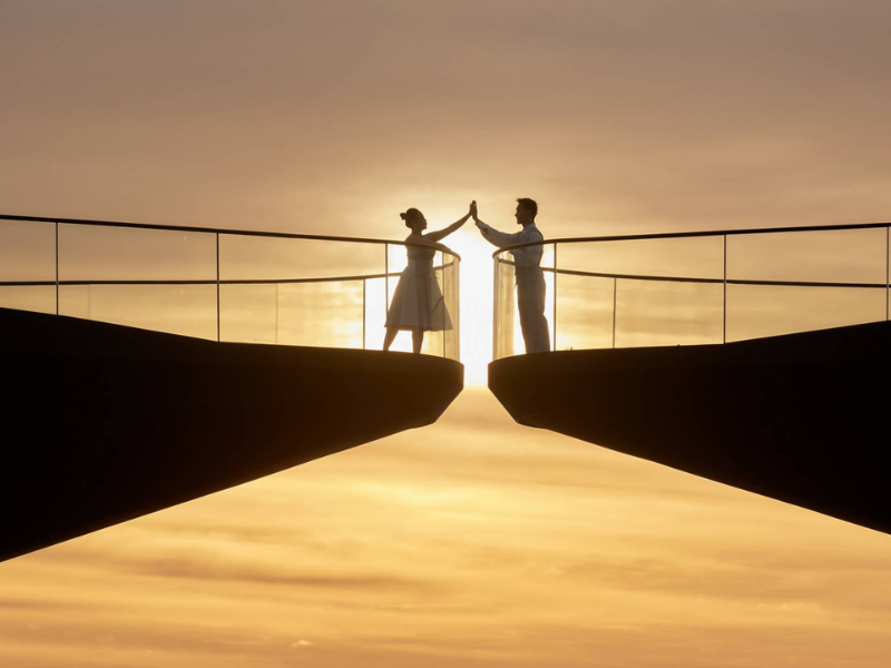 A couple faces each other across the 30 cm gap at the tips of Kiss Bridge, Phu Quoc