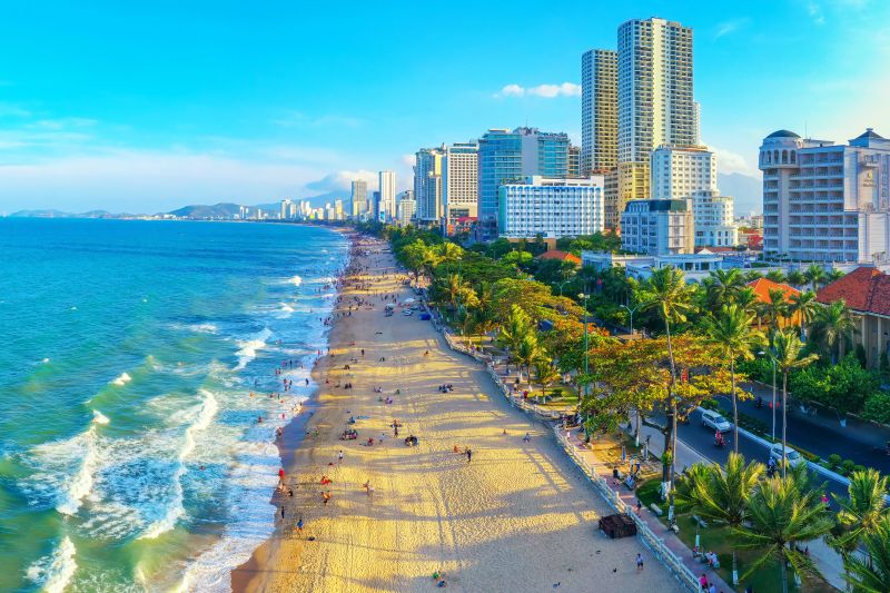 Best time to travel from Hanoi to Nha Trang clear blue sky calm turquoise sea at Nha Trang beach during dry season February to April