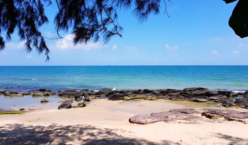 Phu Quoc beach in November during transition from monsoon to dry season with calming Andaman Sea and partly cloudy sky