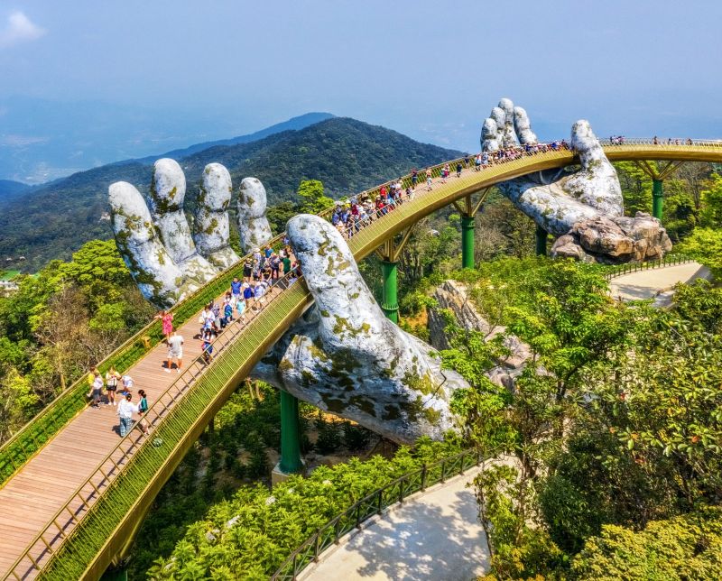 Golden Bridge at Ba Na Hills summit held by giant stone hands at 1,414 meters elevation, accessible from Da Nang via 25 km drive plus 5.8 km cable car
