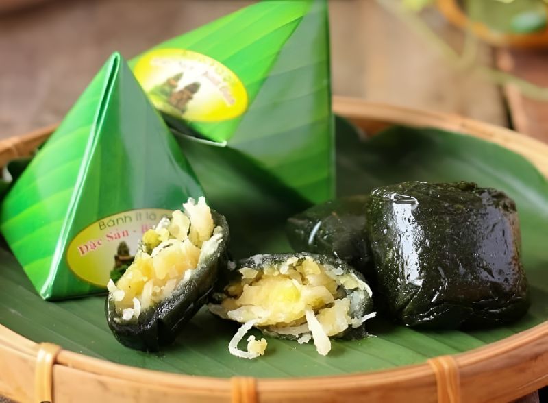 Banh It La Gai dark glutinous rice cakes wrapped in banana leaf and a bowl of Che Bap Hoi An thick sweet corn pudding, two Hoi An-only regional desserts
