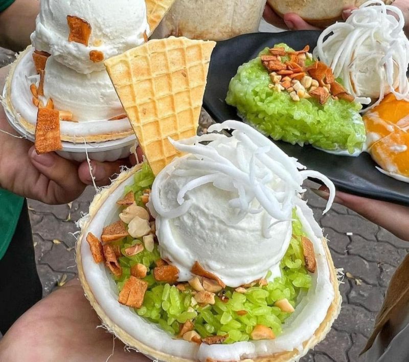 Three Vietnamese street ice creams on display — Kem Xoi sticky rice with peanuts, Kem Bo pale-green avocado ice cream, and a Trang Tien single-scoop cone from Hanoi's 1958 brand