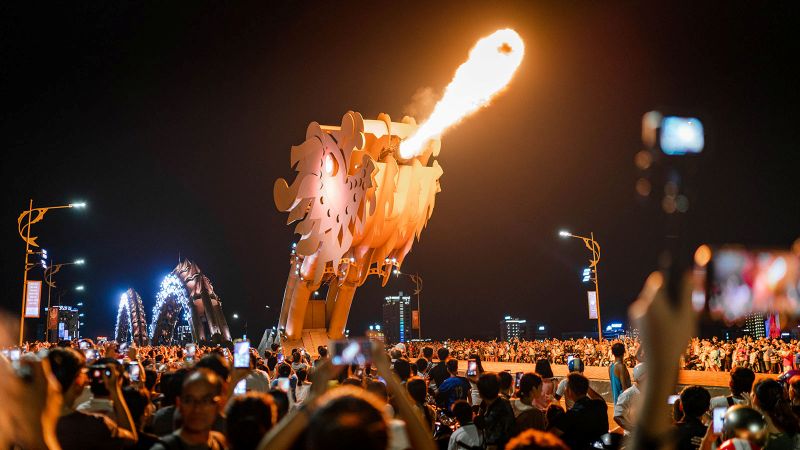 Best photography spot for Dragon Bridge Da Nang from Bach Dang Street riverbank promenade with a direct front-on view of the dragon head