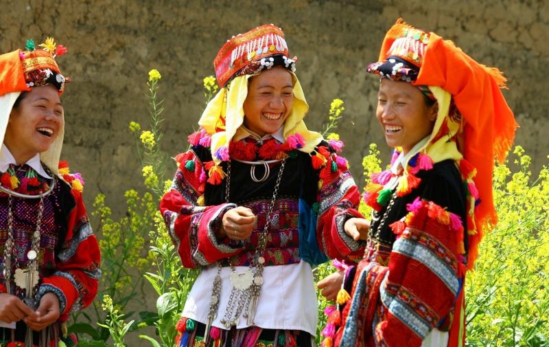 Ethnic minority costumes Vietnam — H'mong women in indigo batik dress and Red Dao women in embroidered headpiece at Sapa Cat Cat Village