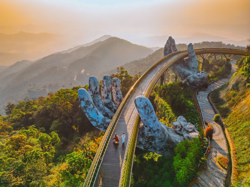 Couple walking Golden Bridge Ba Na Hills morning visit during off-peak hours