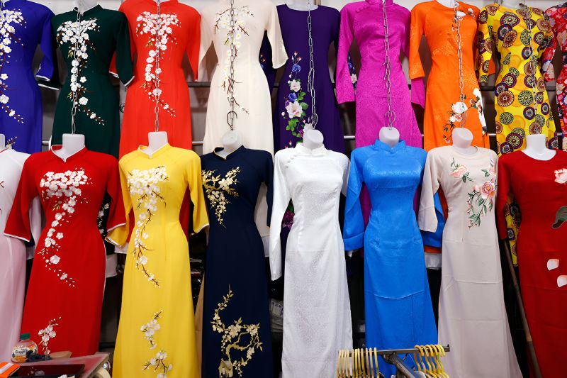 Ready-made Vietnamese ao dai garments in silk fabric hanging at Ben Thanh Market vendor stall
