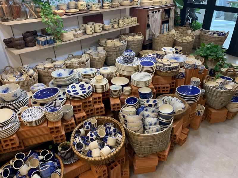 Handpainted Vietnamese ceramic plates and bowls in blue-and-white patterns displayed at a Dong Khoi boutique