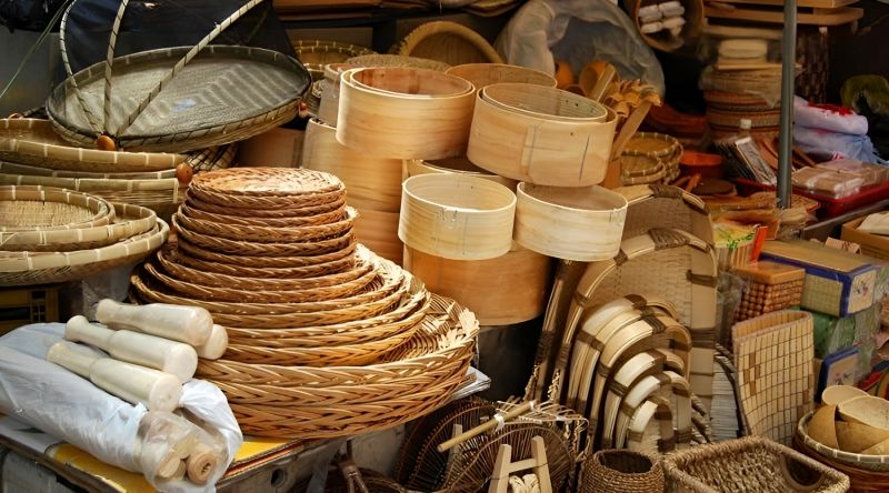 Woven Vietnamese bamboo baskets and serving trays stacked at Binh Tay Market wholesale section