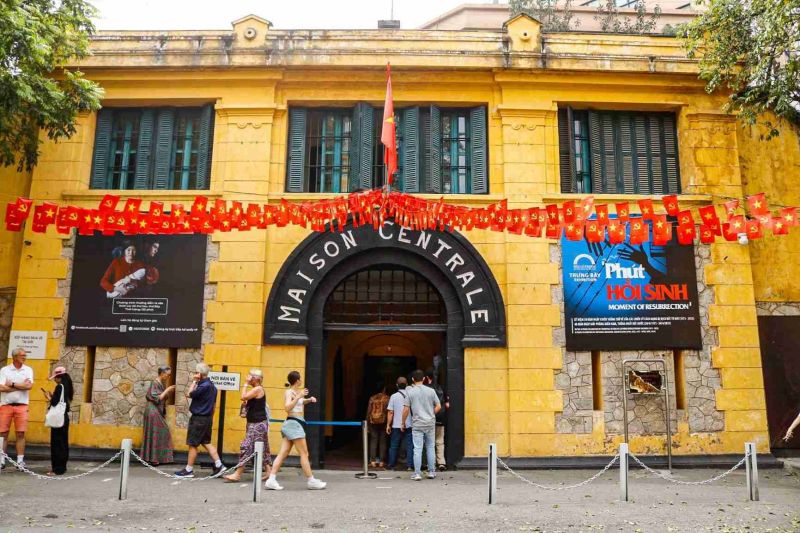 Original detention cells inside Hoa Lo Prison Museum in Hanoi with leg iron exhibits and narrow corridor showing French colonial-era construction