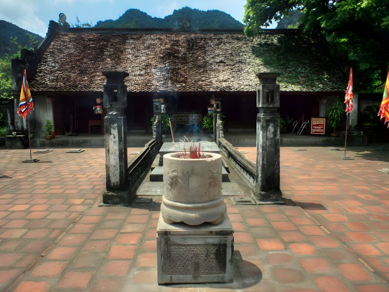 Le Dai Hanh Temple at Hoa Lu Ancient Capital showing 17th-century wooden carvings on hall beams and the Nguyen-era incense burner