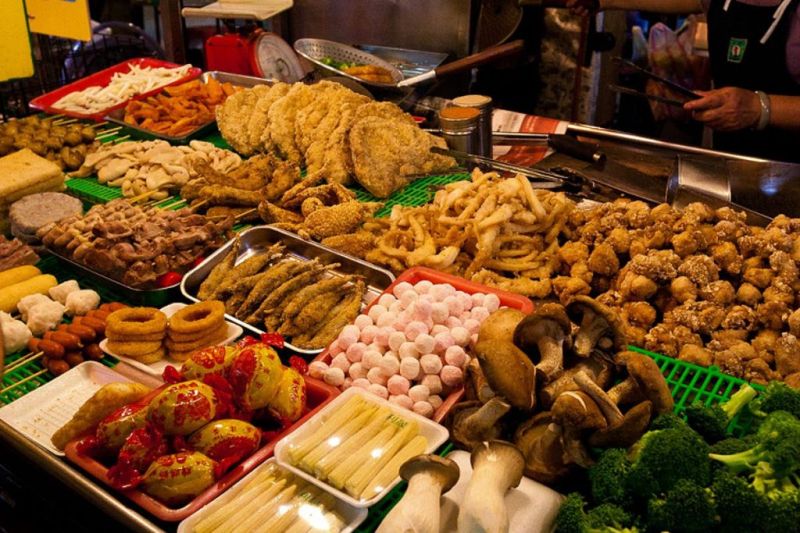 Street food stalls and vendors at southern end of Nguyen Hue Walking Street selling banh mi che dessert and spring rolls