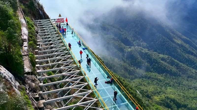 Rong May Glass Bridge wrapped in morning fog at 7:30 AM showing the dragon-cloud effect