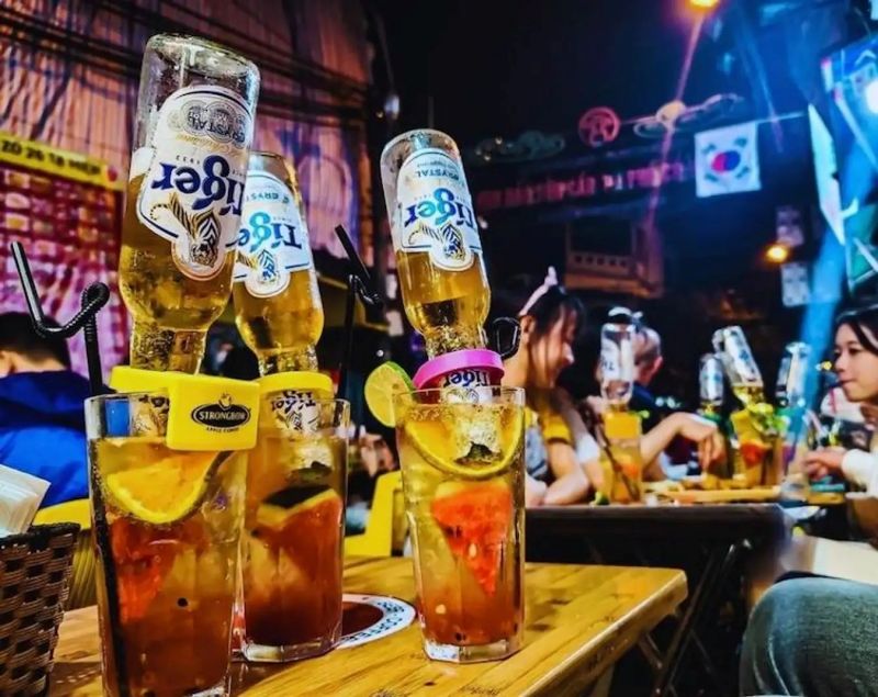 Fresh bia hoi being poured into a 500ml glass at a Ta Hien Beer Street stall in Hanoi at ₹40 per glass