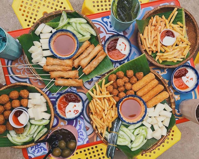 Street food vendor at Ta Hien Beer Street Hanoi grilling skewers and serving snacks to evening visitors