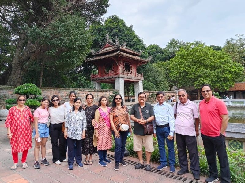 Indian tourist in traditional dress at Temple of Literature respecting Van Mieu modest dress code