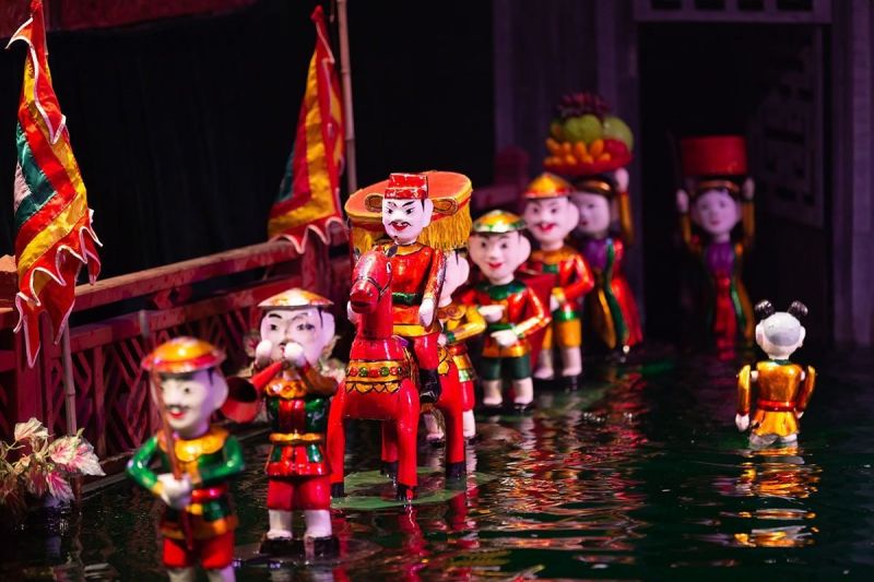 Thang Long Water Puppet Theater dragon scene with water spray pyrotechnic effects and live folk musicians stage-left