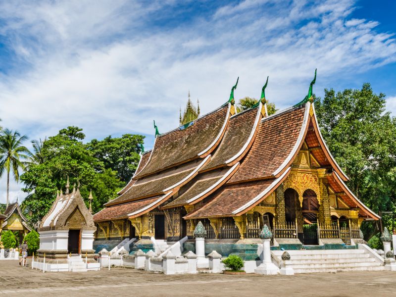 Wat Xieng Thong Buddhist temple in Luang Prabang Laos with golden tree-of-life mosaic and traditional Lao tiered roof