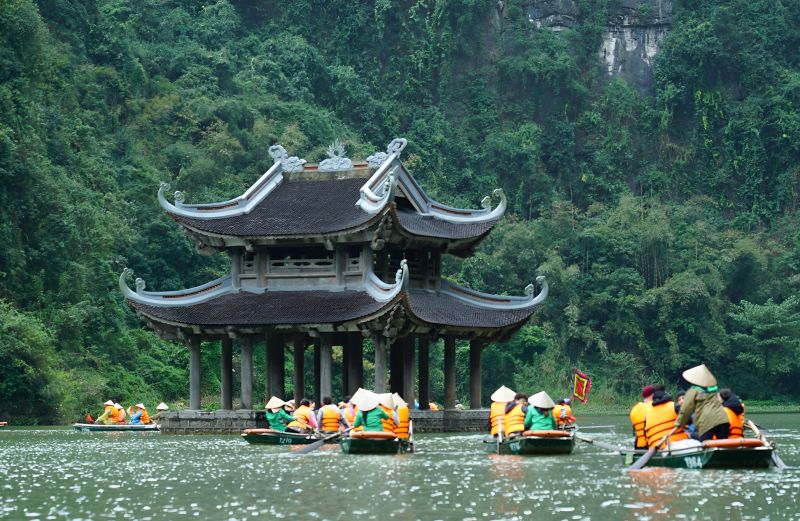 Trang An Scenic Boat Tour in Ninh Binh — UNESCO World Heritage limestone karst landscape with sampan boats passing temples