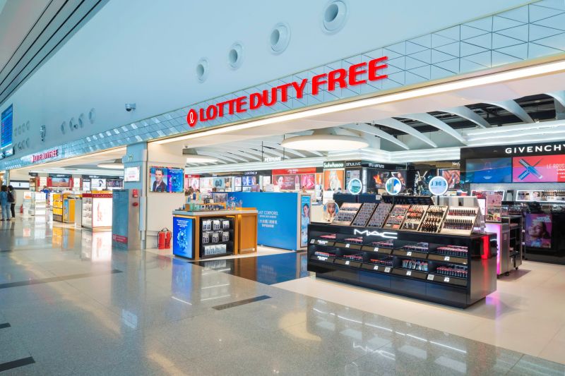 Lotte Duty Free store interior with MAC cosmetics counter and illuminated brand displays in spacious airport terminal