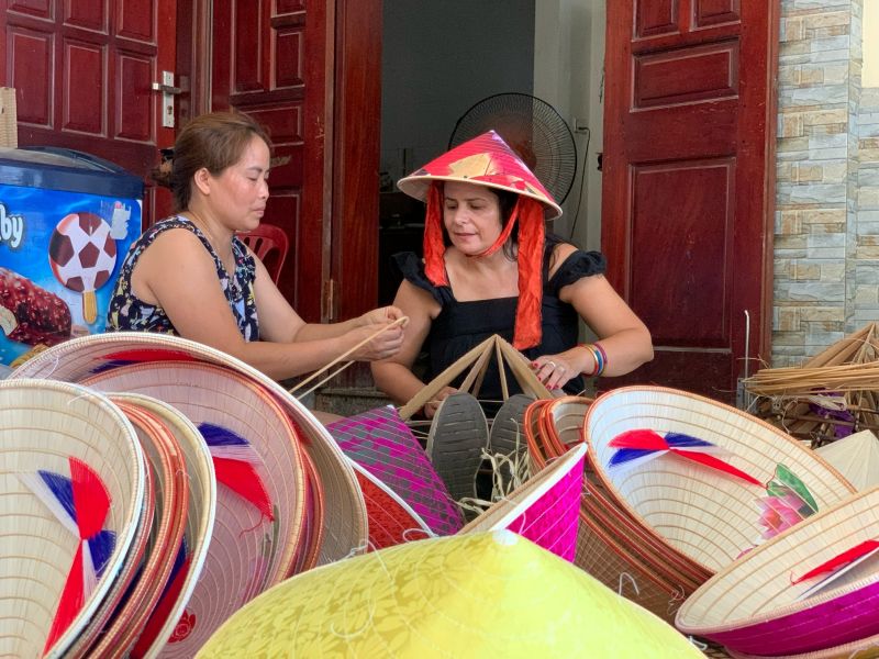 Vietnamese traditional costumes souvenirs — Nón Bài Thơ poem hat, silk Ao Dai scarf, H'mong embroidered bag, and lacquered accessories at Vietnam markets