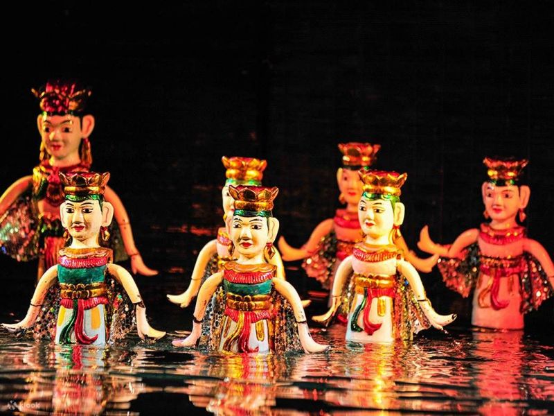 Thang Long Water Puppet Theater stage with bamboo screen and lacquered wooden puppets on water surface during scene