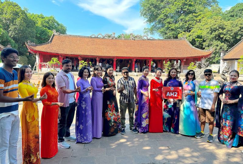 Where to rent Ao Dai Vietnam — tourist wearing rented Ao Dai and Non La at Temple of Literature Hanoi heritage photography session